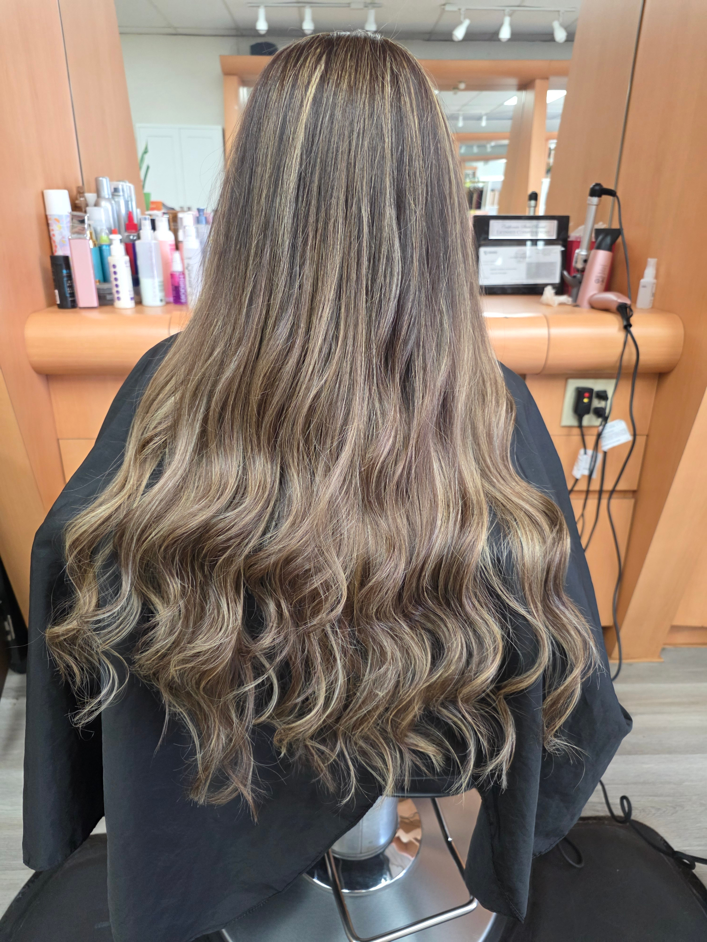 After photo of dimensional balayage with soft waves and shine